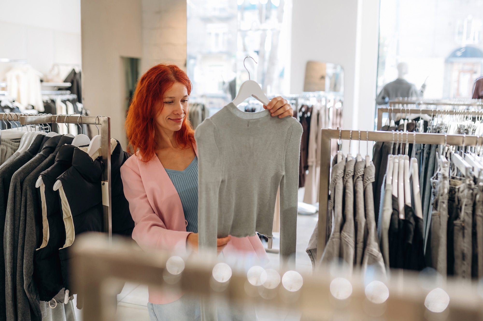 Chooses clothes. Woman is in retail store